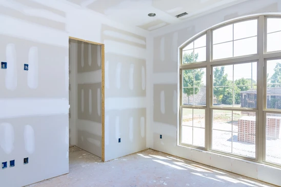 Les murs en pl&acirc;tre de gypse sont en cours de finition pour la peinture dans une nouvelle maison