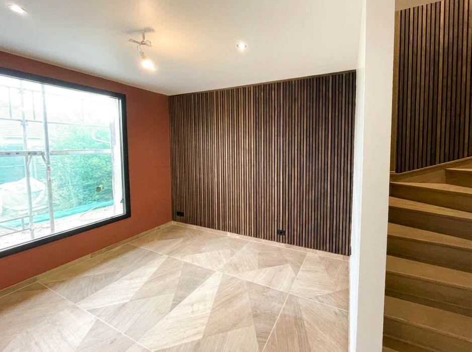 Pièce en cours de finition, vide, avec escalier en bois clair