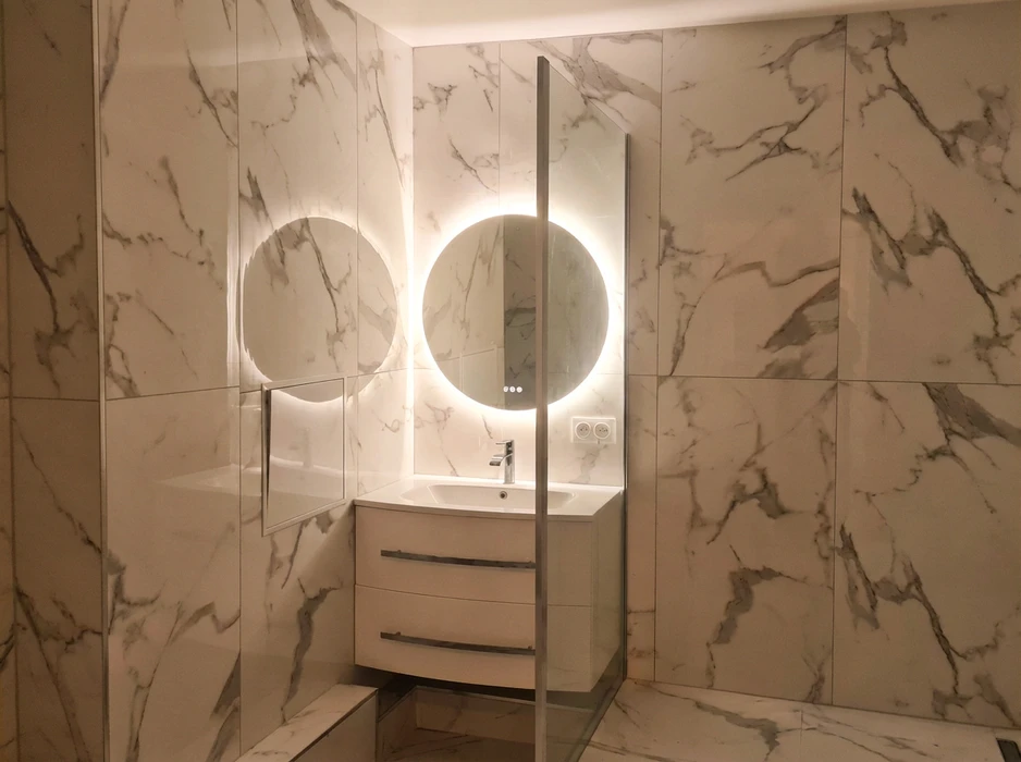 Salle de bain moderne avec revêtement mural en carrelage grand format imitation marbre blanc veiné gris