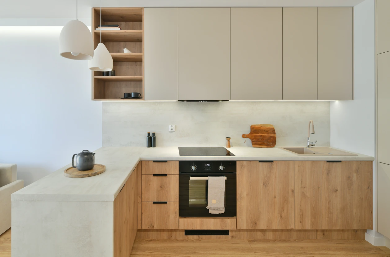 Cuisine moderne avec îlot central, deux tabourets blancs design, plan de travail en bois clair
