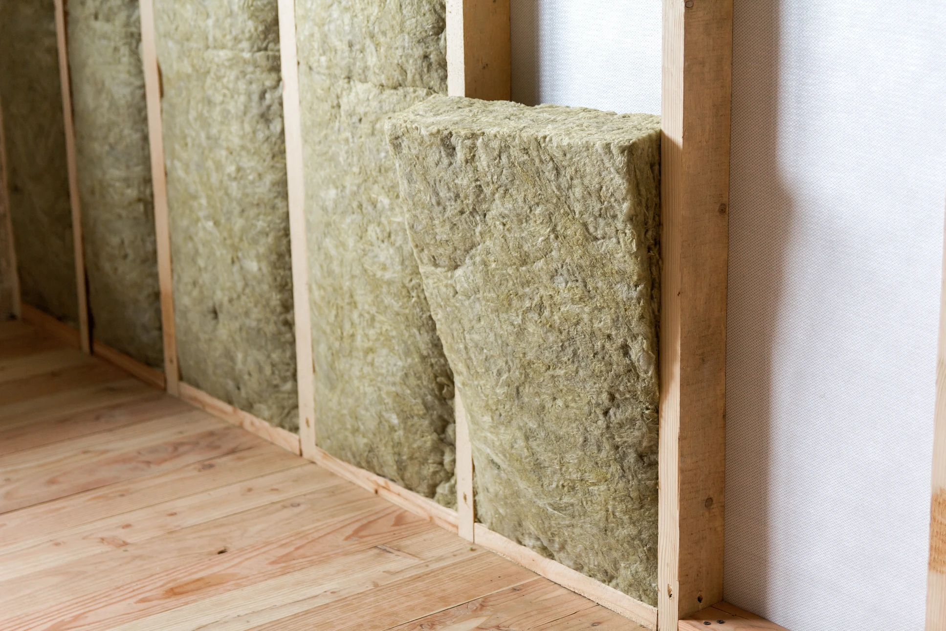 Ouvrier en bâtiment installant de l'isolation thermique dans une construction résidentielle