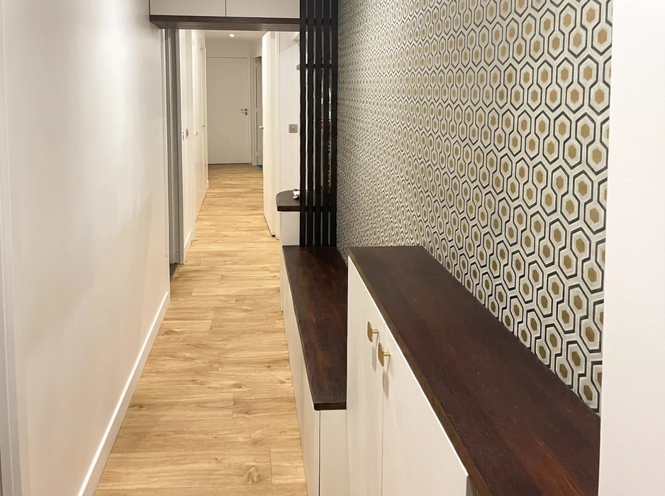 Pièce vide rénovée, carrelage grand format imitation parquet en chevrons, mur bardage bois sombre à lames verticales, mur terracotta avec fenêtre aluminium noire, placard encastré blanc laqué, faux plafond marron, spots LED encastrés
